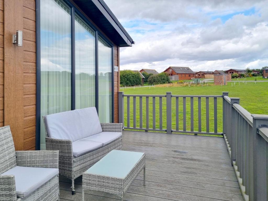 a porch with a couch and chairs on a deck at Cherry Blossom 48 Hot Tub in Garton