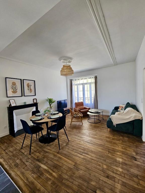a living room with a table and a couch at L'Authentique - Appartement 6 in Loudéac