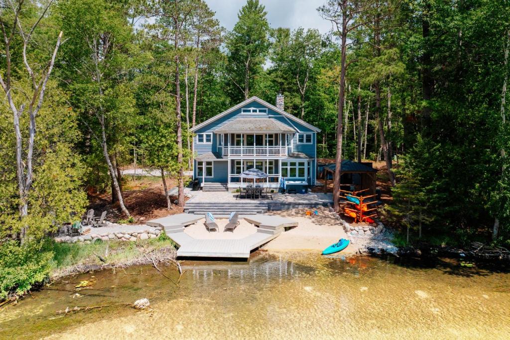 an aerial view of a blue house in the woods at After Dune Delight, 5BR Home Near River in Glen Arbor
