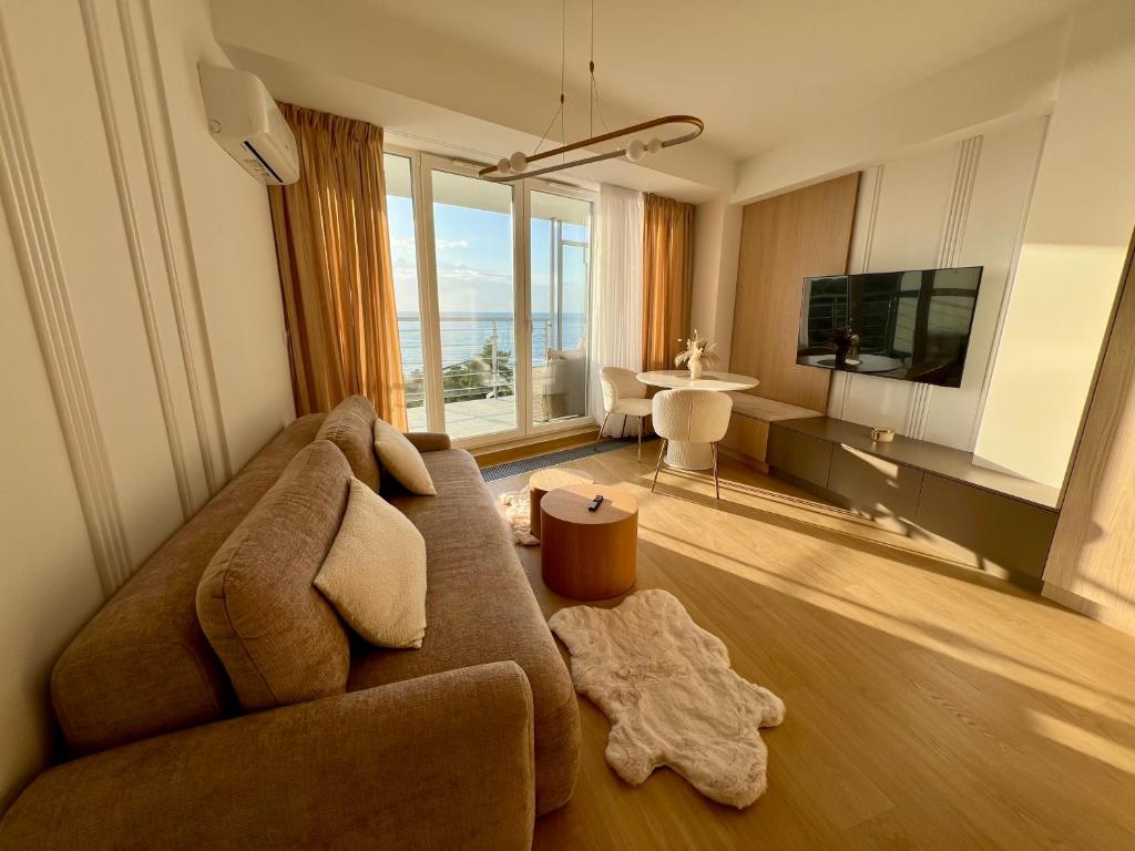 a living room with a couch and a television at Seaglow - z widokiem na morze - Porta Mare in Dziwnówek