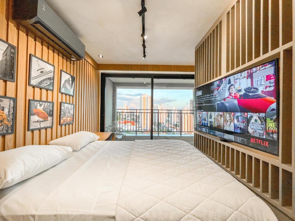 a bedroom with a large television and a bed at Refúgio Tranquilo em Campo Grande in Campo Grande