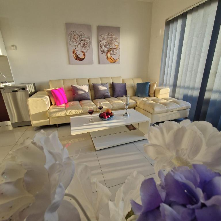 a living room with a couch and a table at Cheerful holiday two bedrooms flat with BBQ in Msida