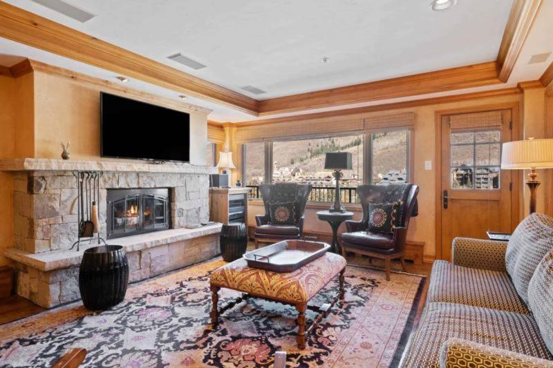 a living room with a fireplace and a tv at Lodge Tower 694 One Bedroom Residence in Vail