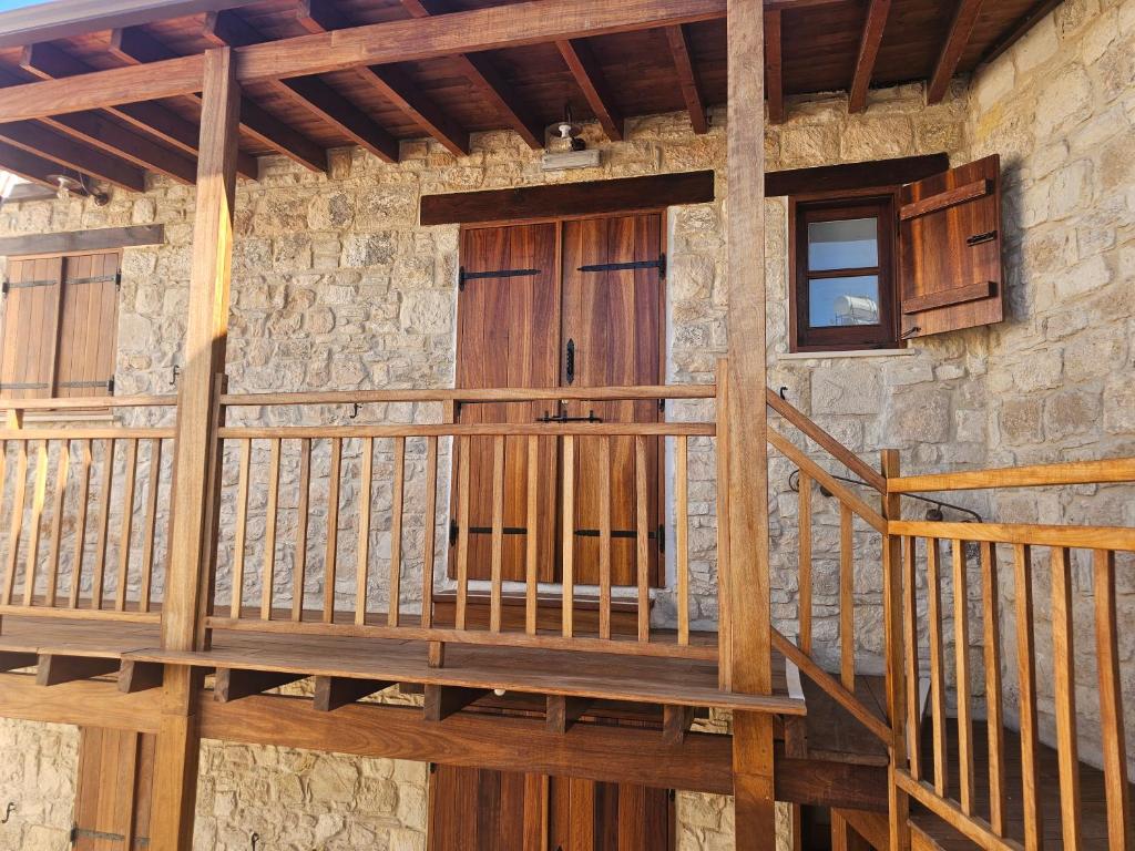 a wooden staircase leading to a building with a door at Katerinas Sweet Place studio 1 in Tsadha