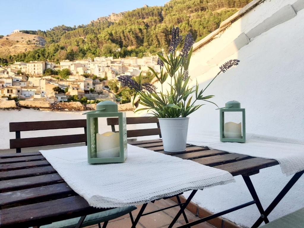 Una mesa de madera con dos velas y una vista de una ciudad. en Casa del Castillo, en Cazorla
