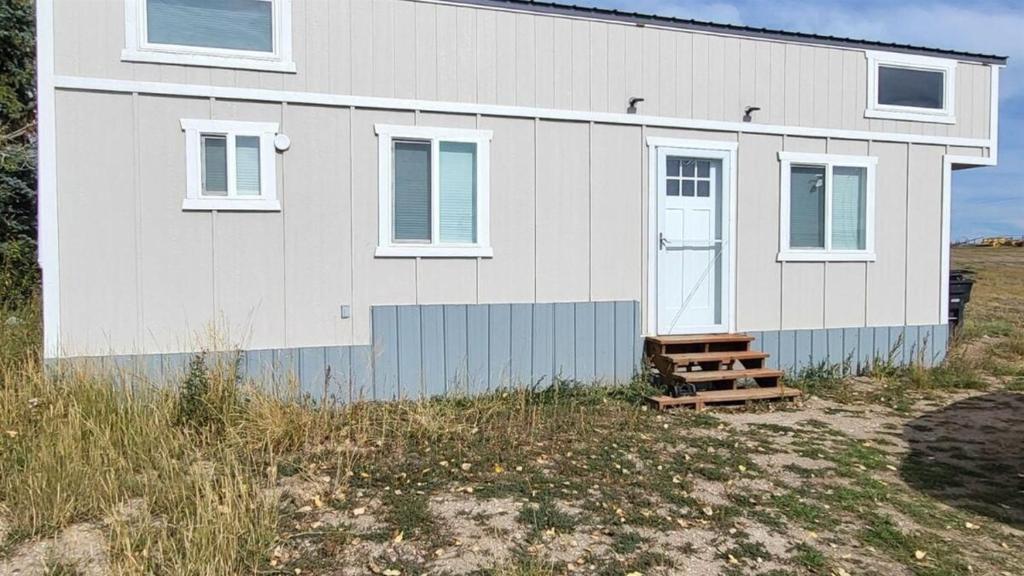 a white house on top of a field at Rate Drop! Enjoy the Simplicity-Teton Tiny House L in Tetonia