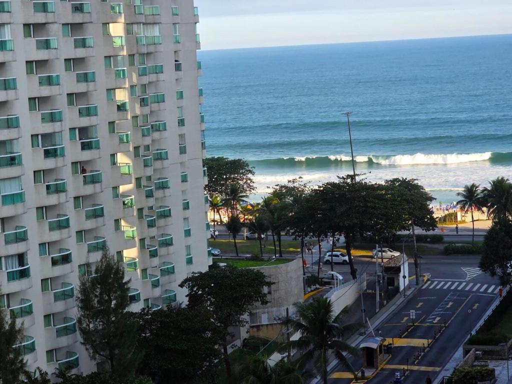 Una vista del océano y un edificio y una playa. en Apartamento Barra da Tijuca Frente Mar, en Río de Janeiro