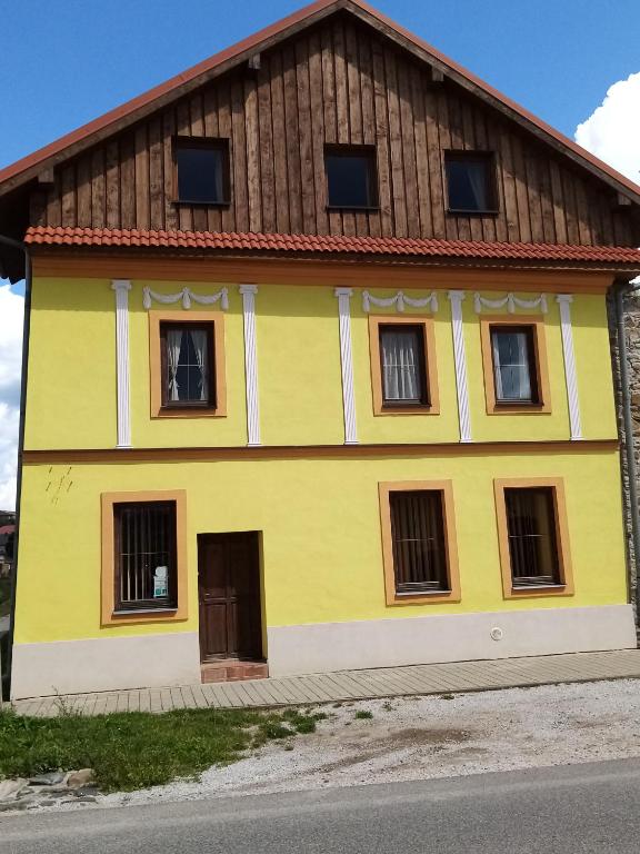 a yellow house with a brown roof at Penzion Toliar in Vrbov