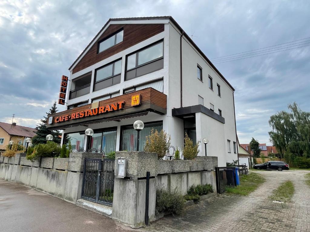 a white building with a sign for a restaurant at Pension De Lux Rain in Rain