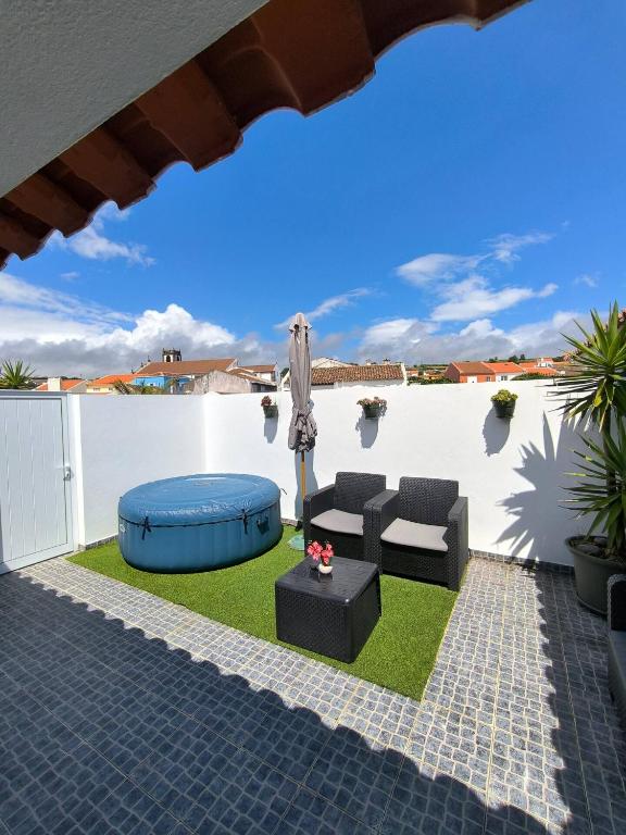a backyard with a patio furniture and an umbrella at Casa do Troféu in Relva
