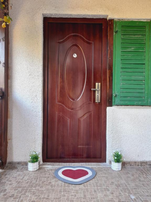 a wooden door with a red heart on a mat in front at Vikendica Katarina in Ovčar Banja