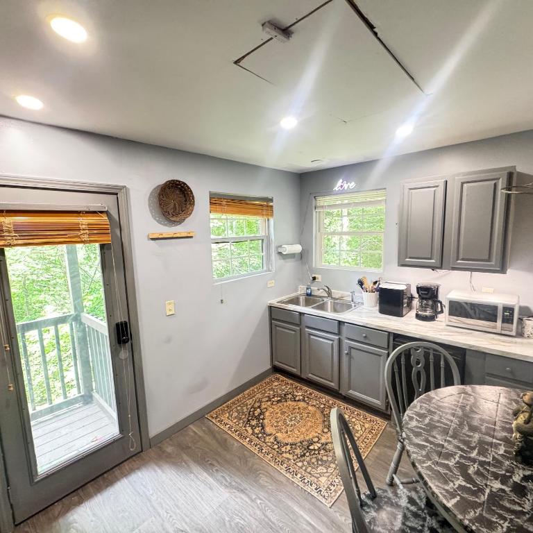 Una cocina con una mesa y un comedor. en Just Listed! THE GROTTO w In Suite Jacuzzi-Pets Welcome 420 Friendly Apartment, en Gatlinburg
