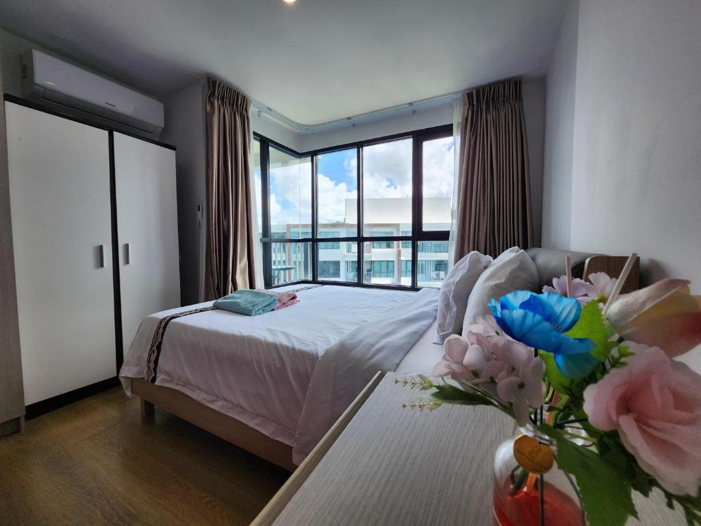 ein Schlafzimmer mit einem Bett und einem Tisch mit einer Blumenvase in der Unterkunft cen 1 bed room862 in Ban Rangeng