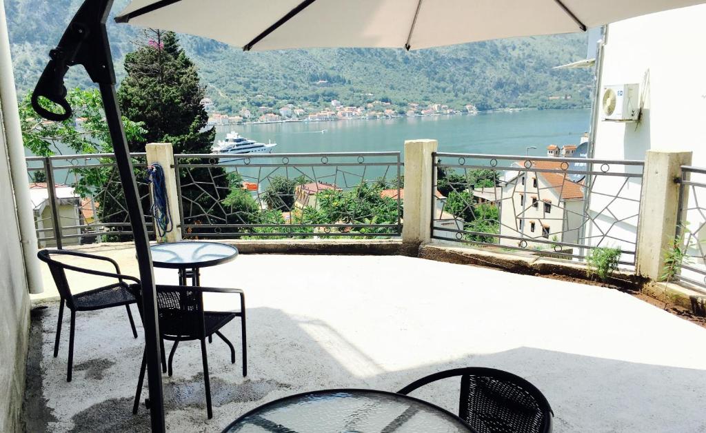 a balcony with a table and chairs and an umbrella at Apartments Parapid in Kotor