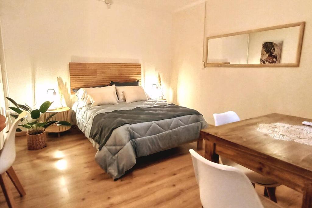 a bedroom with a bed and a table with chairs at ORIGEN Centro Monoambiente in El Bolsón