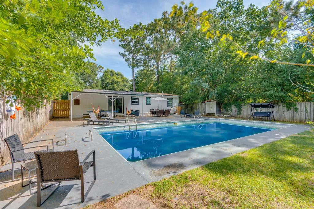 Un patio trasero con piscina y una casa. en Game, Swim and Explore Family Home in Pensacola, en Pensacola