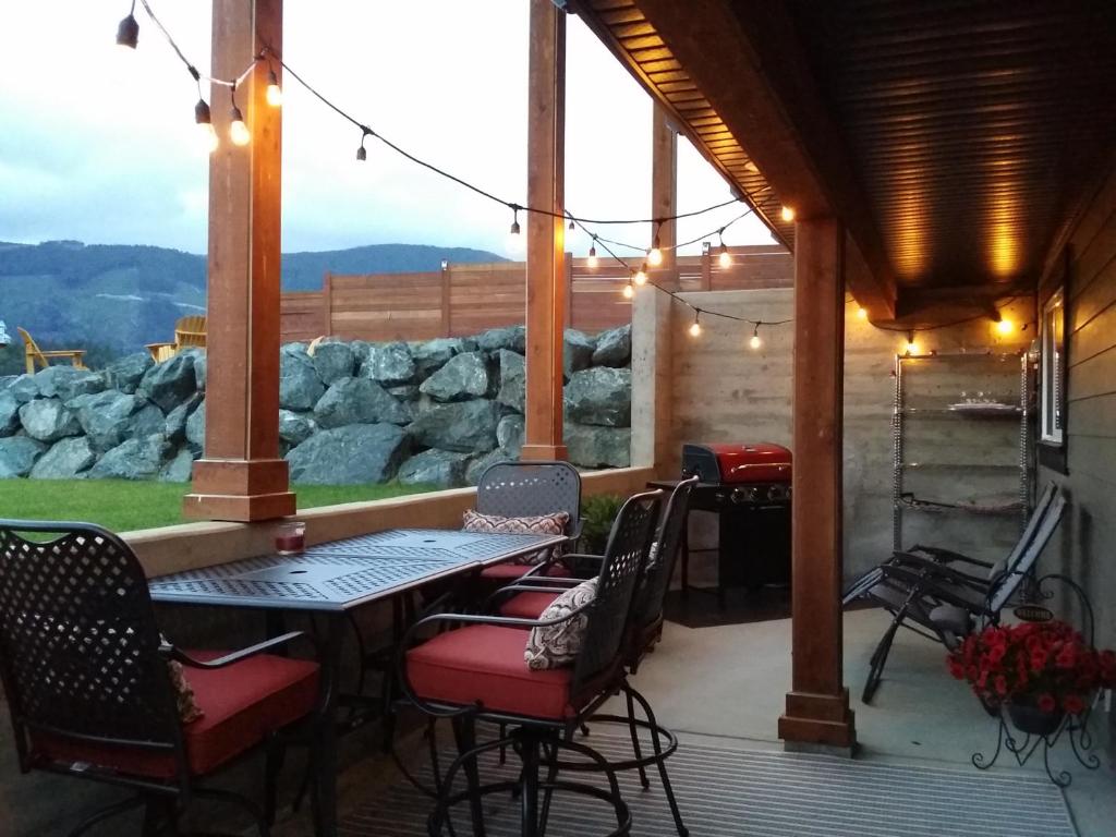 a patio with a table and chairs and a view at Cowichan Calling in Lake Cowichan