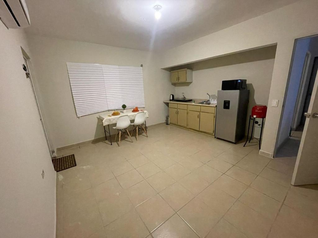 a small kitchen with a table and a refrigerator at Departamento en Hermosillo in Hermosillo