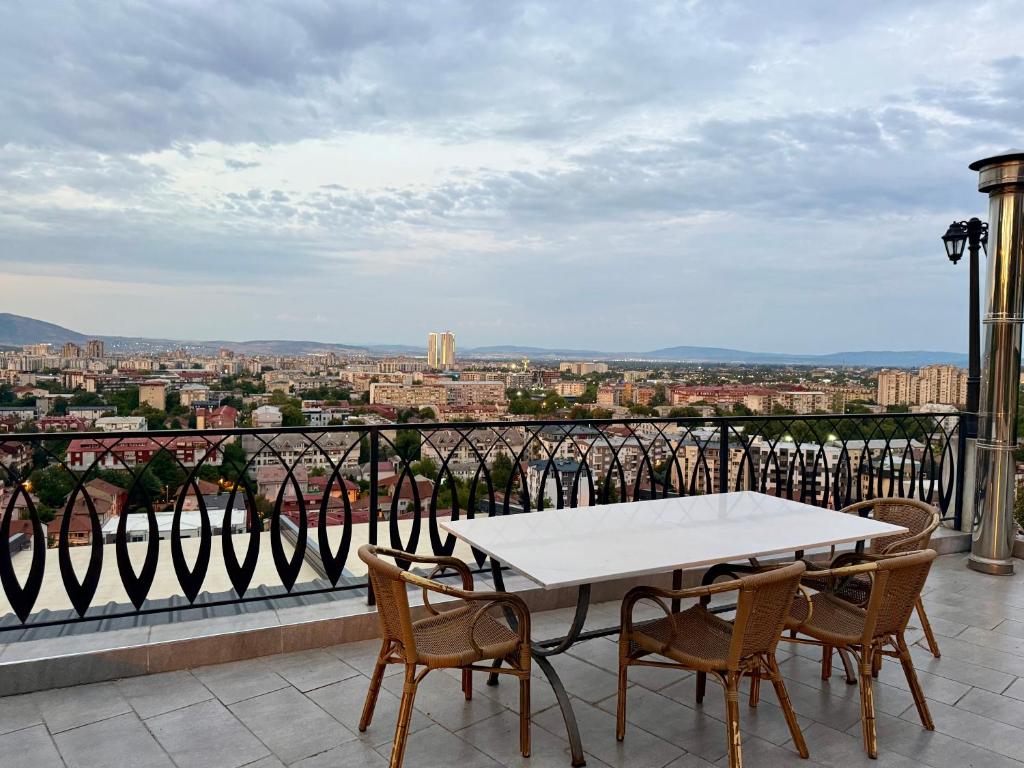 a table and chairs on a balcony with a view at Villa Eleni Apartments Skopje in Skopje