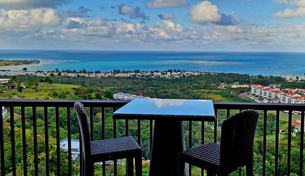 里奥格兰德Brisa's De Puerto Rico B302的阳台上的桌子和椅子，可欣赏大海