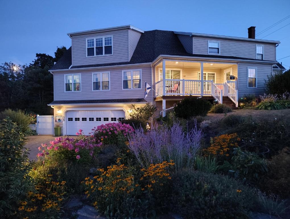 a house with a porch and flowers in the yard at Digby Bed and Breakfast in Digby