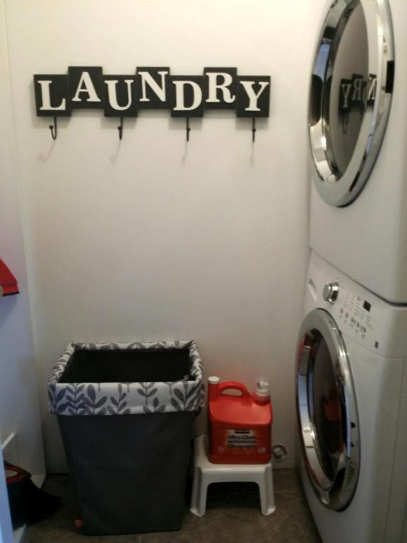 a laundry room with a washing machine and a laundry basket at Cowichan Calling in Lake Cowichan