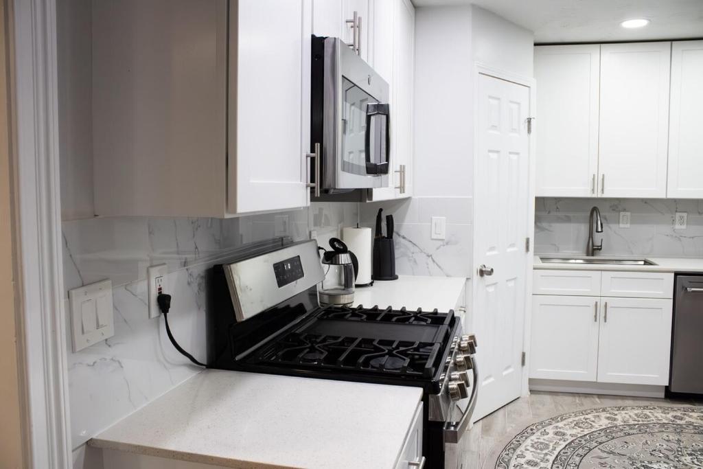 a kitchen with white cabinets and a stove top oven at Lovely 3-Bedroom Duplex in Douglasville