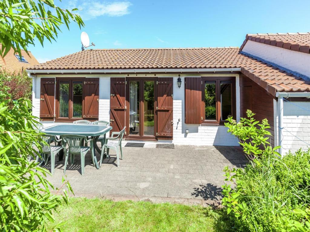 a patio with a table and chairs in front of a house at Holiday Home in Bredene near Sea and Lake in Bredene