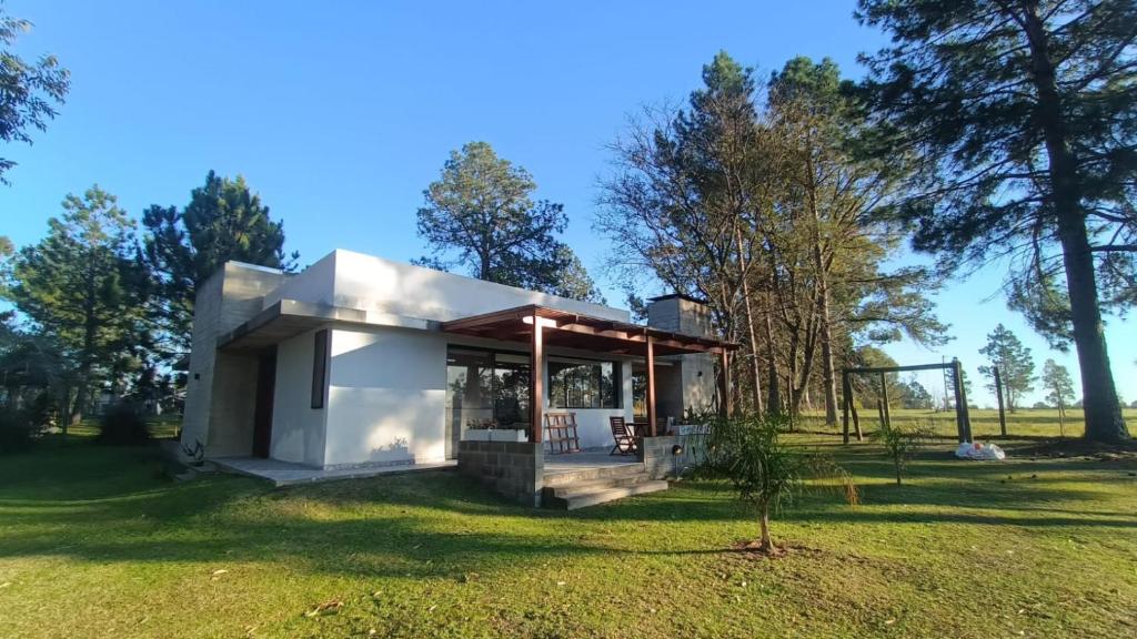 a small white house in a field with trees at El Paraíso - Casa rural en zona termal de Concordia in Concordia
