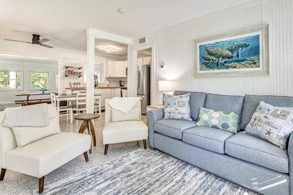 a living room with a blue couch and chairs at Walk to Crystal River Home with Lanai and Yard! in Crystal River