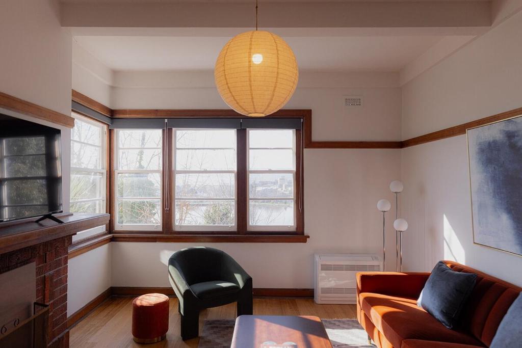 un salon avec un canapé et une chaise dans l'établissement Tamar River Views Mid-Century Vibes, à Royal Park