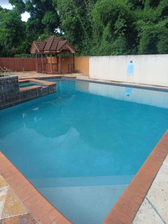 a large blue swimming pool with a gazebo at Embassy Royale in Kingston
