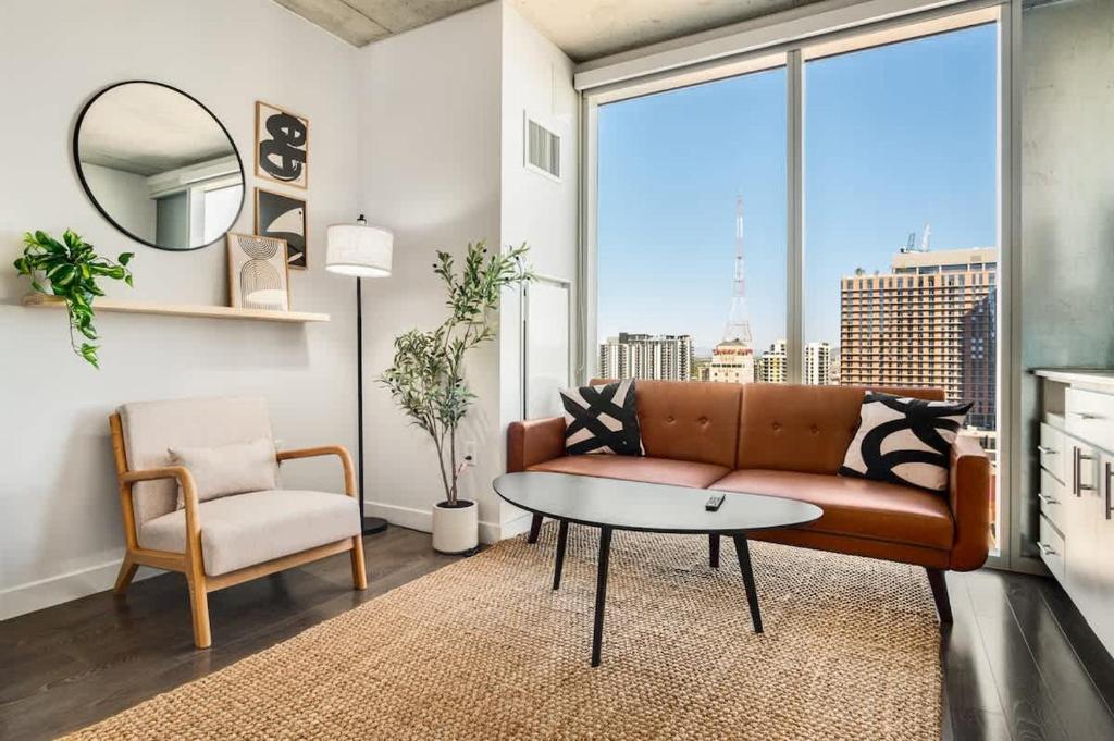 a living room with a couch and a table at Boulevard Stays Downtown Highrise STU Sky Pool Parking Gym 05 in Phoenix