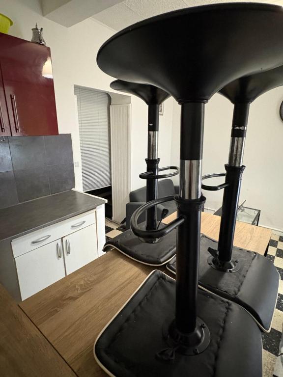 Una cocina con una estufa negra en una habitación. en Le study, en Béziers
