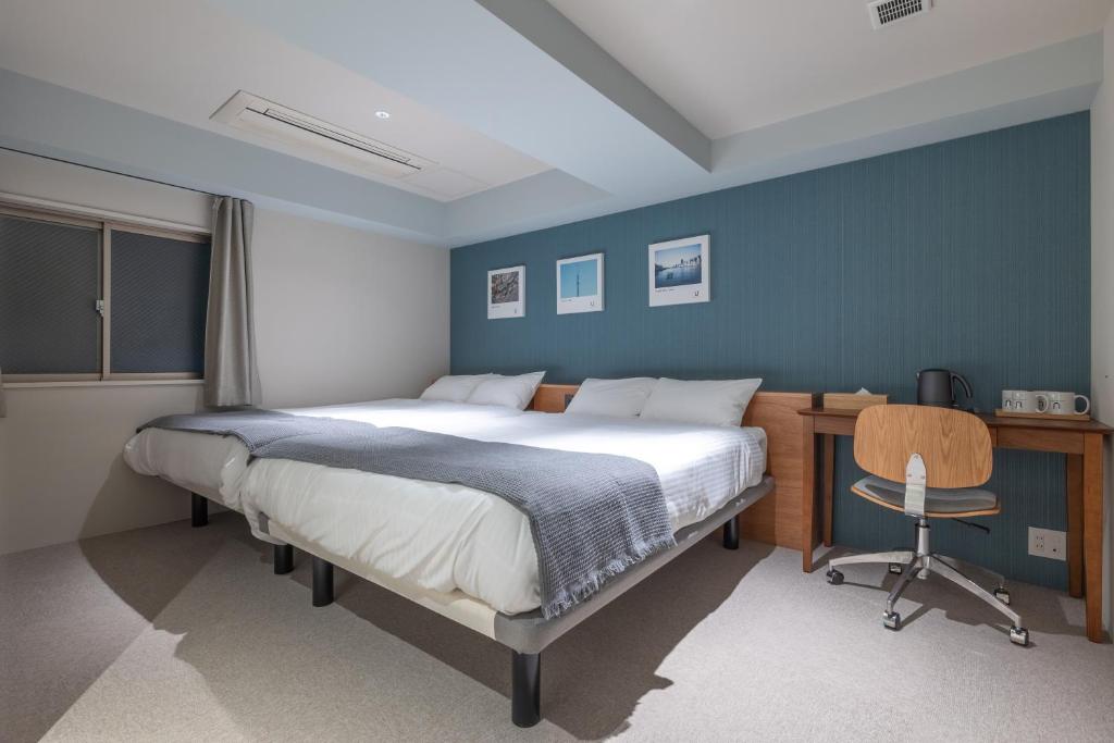 a bedroom with a bed and a desk and a chair at 9STAY Kikukawa in Tokyo