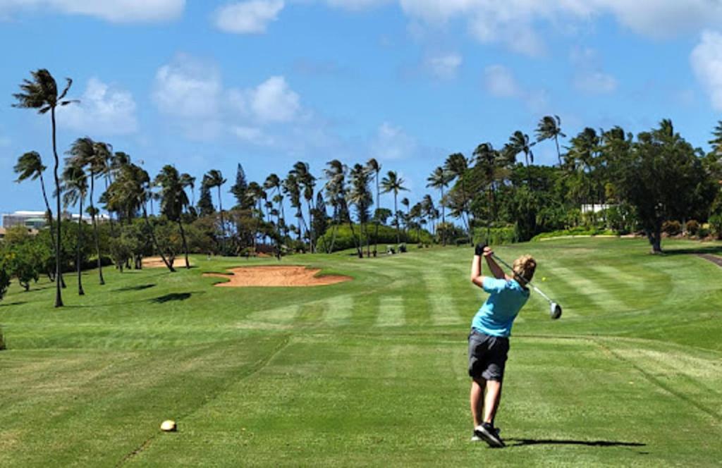 Una donna che dondola una mazza da golf su un campo da golf di KBM Resorts FREE CAR Kaanapali Royal Ocean view Stunning Remodeled 2-Bedroom Villa at Kaanapali Royal KRO-L201 a Lahaina