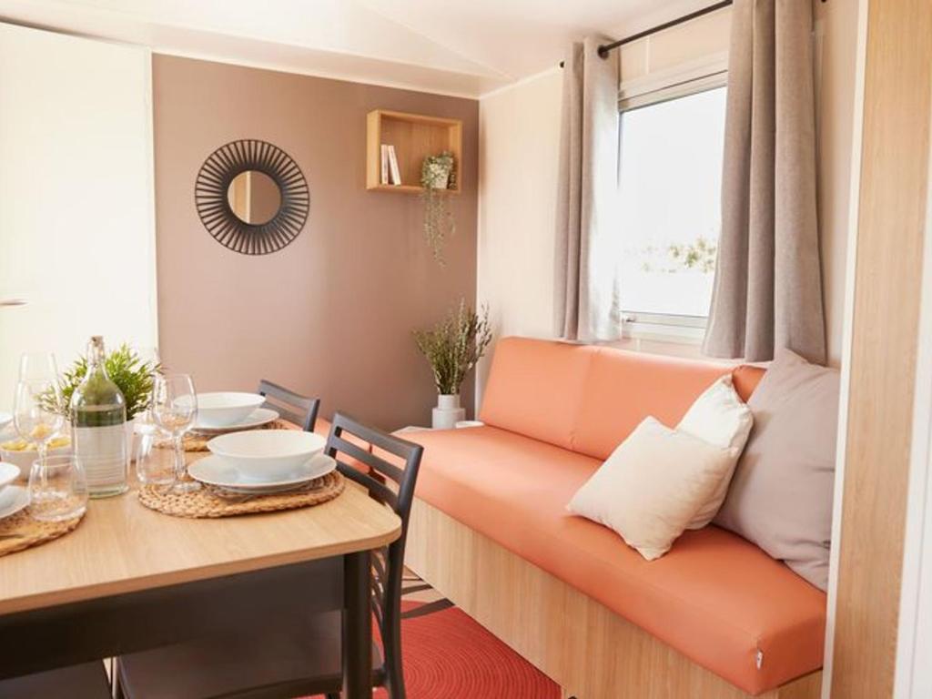 a living room with a couch and a table at Mobil home 6 pers avec terrasse, 3 chambres - API-1-52-651 in Saint-Maurice-dʼIbie