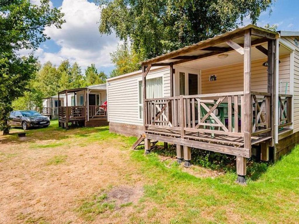a group of mobile homes with a car parked in the yard at Mobil home moderne avec terrasse pour 4 personnes - API-1-52-468 in Granges-Aumontzey