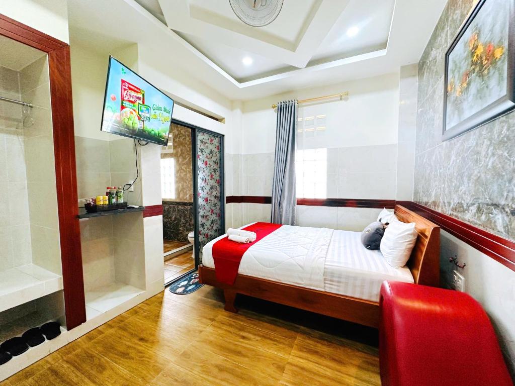 Un dormitorio con una cama y un televisor en una pared. en Khách Sạn Hoàng Thanh Thủy 4, en Ho Chi Minh