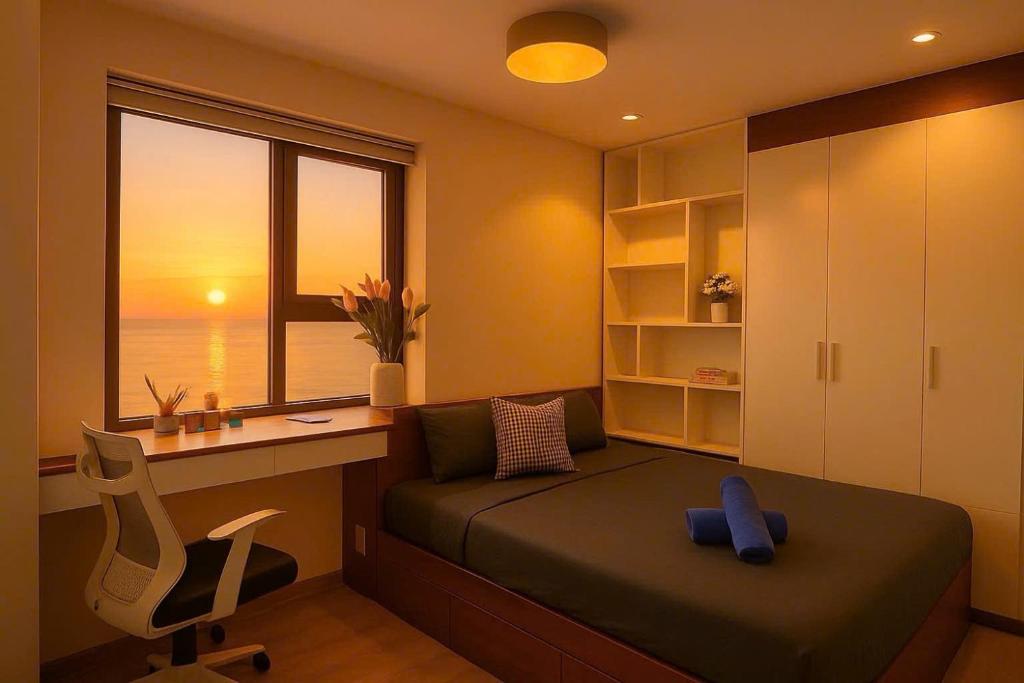 a bedroom with a bed and a desk and a window at Da Nang Daisy Apartment in Danang