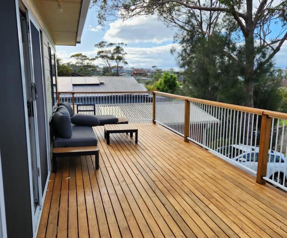 a porch with a chair and a table on a deck at Souira Beach House in Manyana