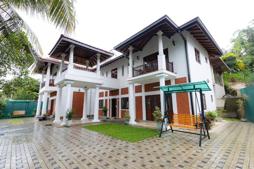 a large white building with a playground in front of it at Ceylon Holiday Homes in Kandy