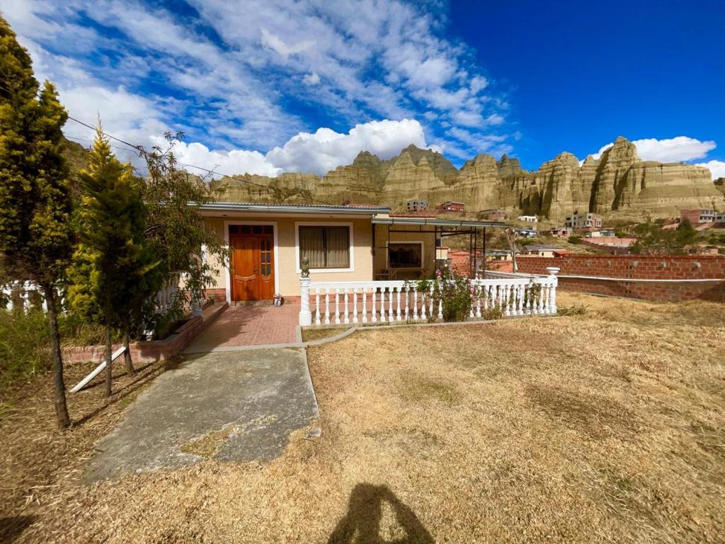 ein Haus mit einem Zaun vor einem Berg in der Unterkunft Casa de campo - Flor del valle in La Paz