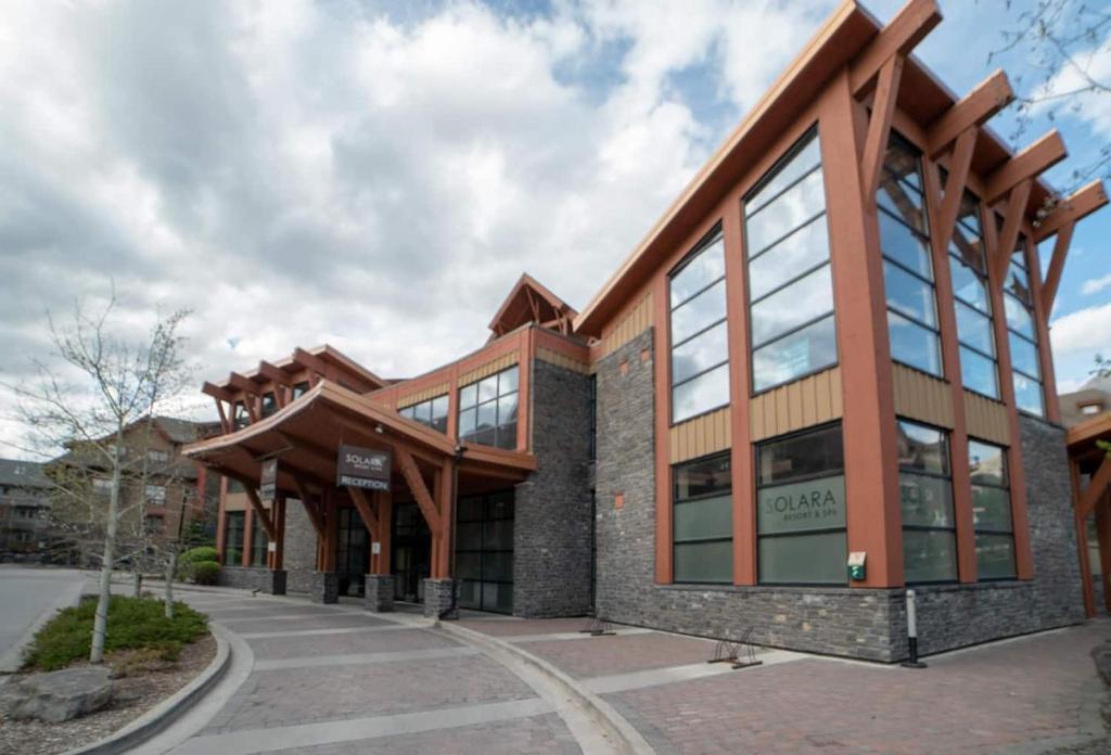 a large building with glass windows on the side of it at Luxury Penthouse - 3 King Suites - Ug Parking in Canmore
