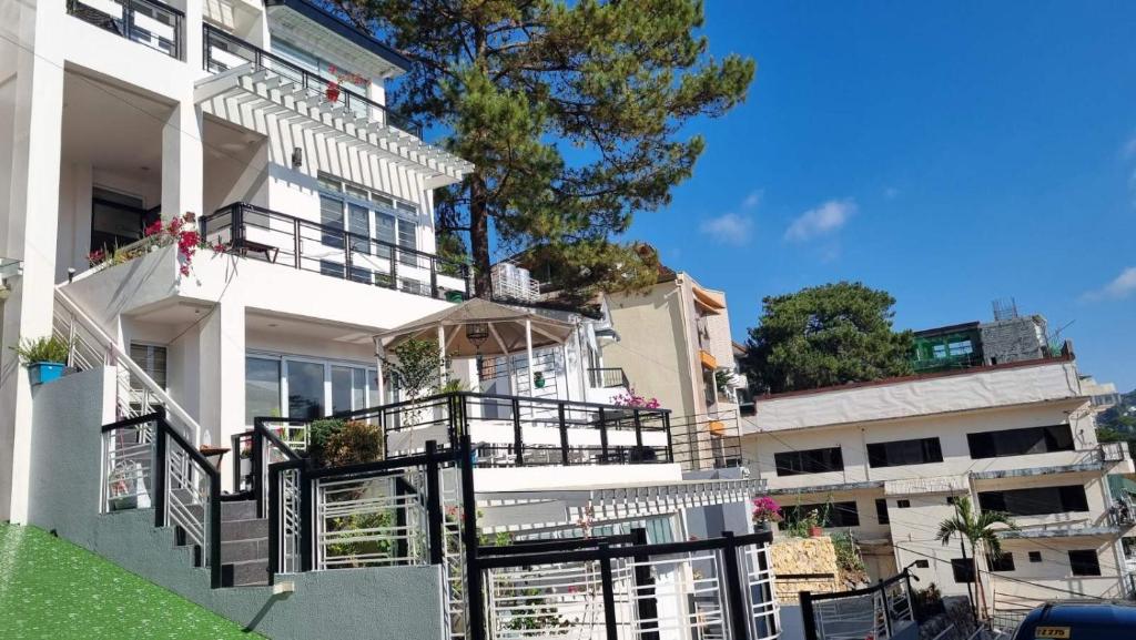 a white building with a black fence in front of it at Baguio Brentwood Villas in Baguio