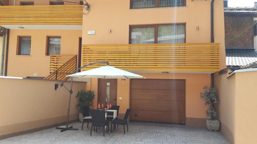 a patio with a table and chairs and a building at Rooms and Apartment Soča Kobarid in Kobarid