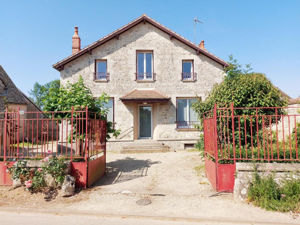an old house with a red gate in front of it at Maison authentique pour 10 pers, Beauce - FR-1-581-156 in Moutiers
