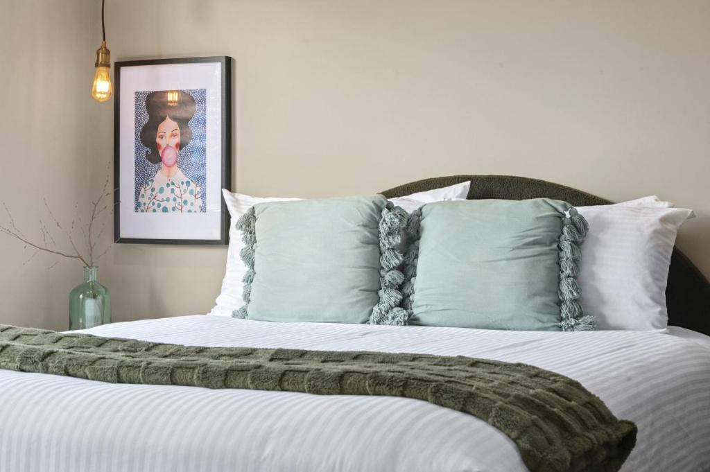 a bedroom with a large bed with white sheets and pillows at Evies Cottage i Belmont Suites I regionalXscapes in Belmont