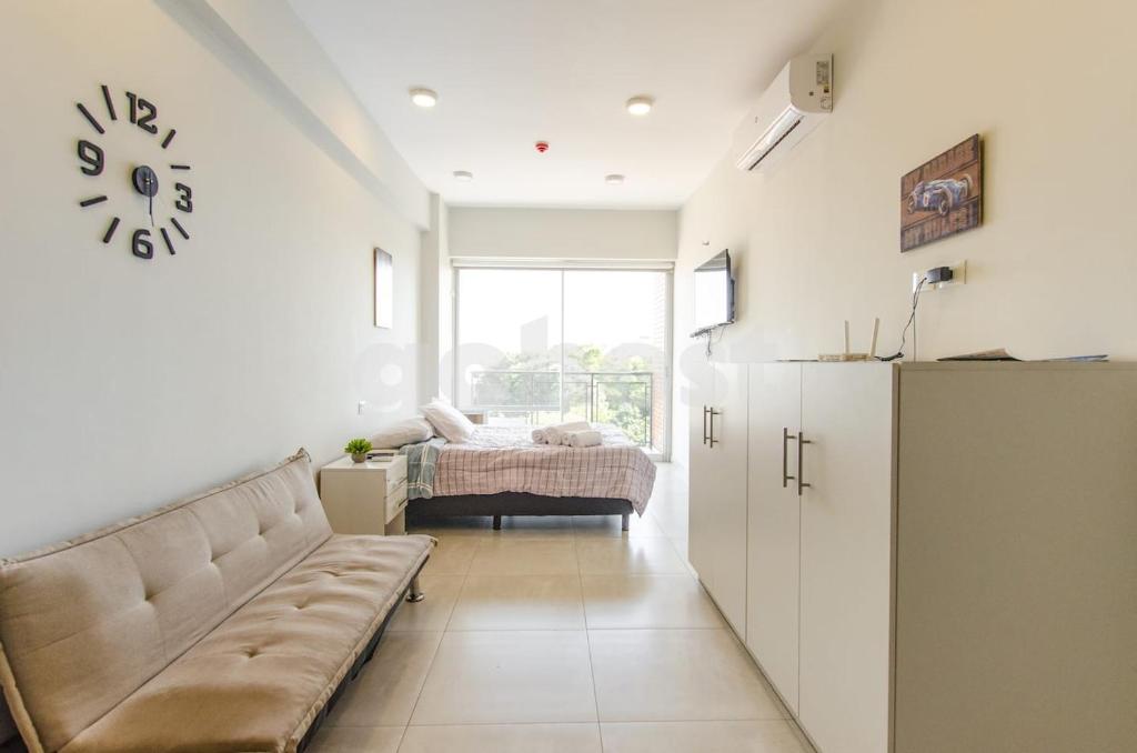 a living room with a couch and a bed at Comfortable Villa Morra Loft in Asuncion