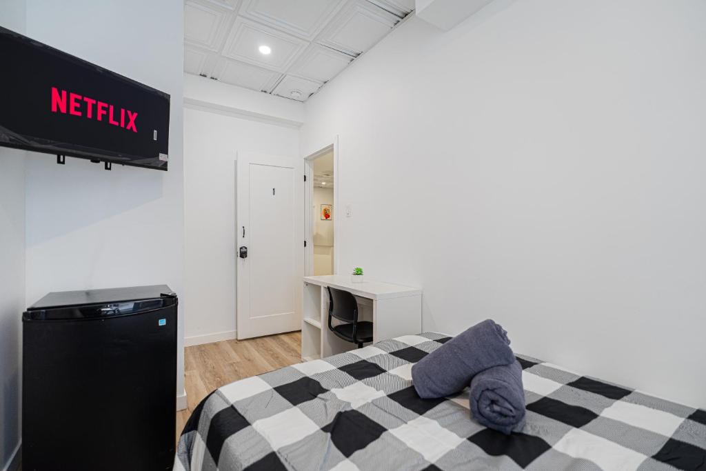um quarto com uma cama xadrez preta e branca e uma escrivaninha em Room 1 - apartment 2 in a SHARED apartment em Montréal